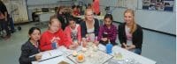 Groß und Klein an einem Tisch beim Projekt Feuer und Flamme an der Gesamtschule Fröndenberg (GSF).